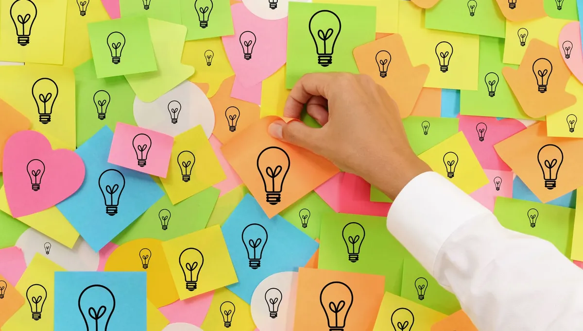 Mural de post-its com ícones de lâmpada recebendo mais uma nota